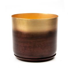 a brown and gold vase sitting on top of a white table