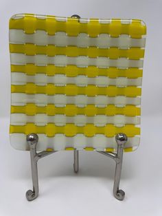 a yellow and white object sitting on top of a metal stand