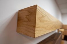 a wooden shelf mounted to the side of a wall