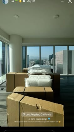 an open box sitting on top of a wooden floor next to boxes in front of large windows