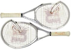 two tennis racquets that have been scratched and stained white with red writing on them