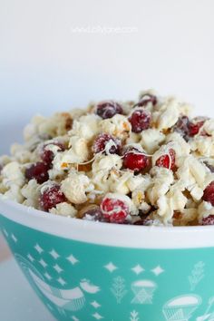 a bowl filled with cereal and cranberries on top of a table