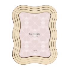 a wooden frame with the words kate spade on it in white and pink geometric shapes