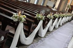 rows of pews decorated with flowers and candles