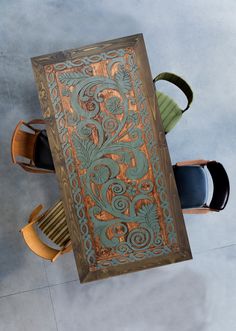 an overhead view of a table with chairs and a large painting on the wall above it