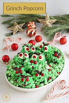 a white bowl filled with green and red rice krispy treats next to candy canes