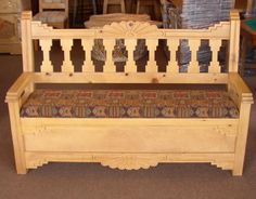 a wooden bench with a patterned seat cushion