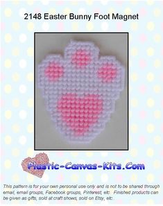 a pink and white crocheted bunny foot magnet on a blue polka dot background