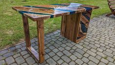 a wooden table sitting on top of a brick walkway