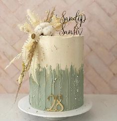 a cake decorated with grass and flowers on top of a white tableclothed surface