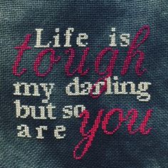 the back of a sweater with words written in red and white on it, which reads life is tough, my doing but so are you