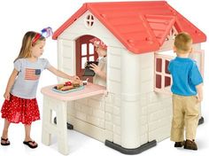 two children are playing with a doll house