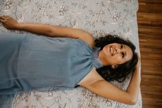 a woman laying on top of a bed next to a wooden floor