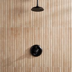 an overhead view of a shower head and hand held shower faucet on a wood paneled wall