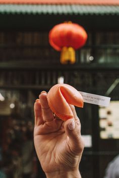 a person holding up a piece of food in their hand with a business card attached to it