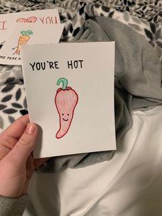 someone holding up a card with a drawing of a hot pepper on it that says, you're hot