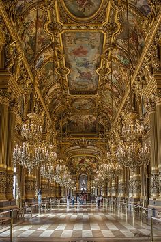 an ornately decorated hall with chandeliers and paintings on the ceiling