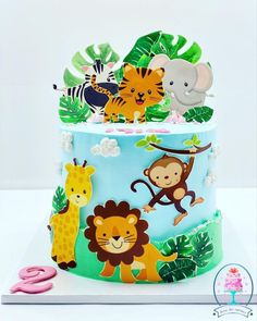 a three tiered cake decorated with jungle animals