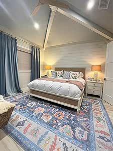 a bedroom with a large bed and blue curtains