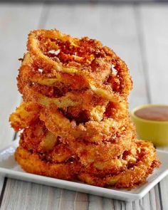 fried onion rings on a plate with dipping sauce