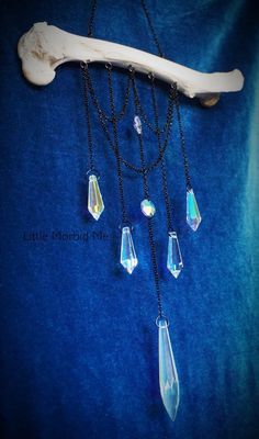 a long necklace with crystal drops hanging from it's sides on a blue background