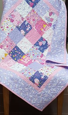 a pink and blue quilt on a wooden chair