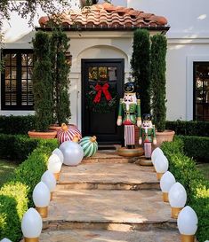 an entrance to a home decorated for christmas with decorations and balloons on the front steps