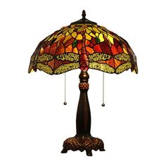 a lamp that is sitting on top of a wooden stand with a dragonfly design on it