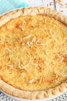 an uncooked pie with cheese and parmesan toppings sits on a plate