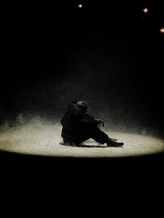 a person sitting on the ground in the dark