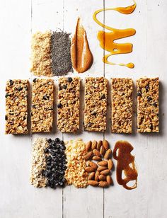 an assortment of granola bars, nuts, and orange juice on a white table