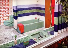 a bathroom with colorful tiles on the walls and floor, along with a green bathtub