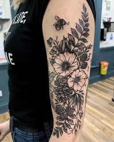 a woman with a black and white flower tattoo on her arm