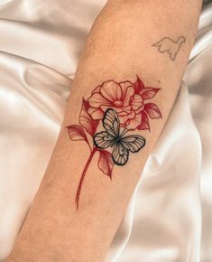 a butterfly and flower tattoo on the arm