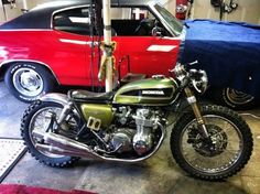 a motorcycle parked next to a car in a garage