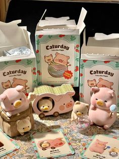 three little pigs sitting on top of a table next to some milk boxes and cards