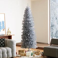 a living room with a christmas tree in the middle and presents on the floor next to it