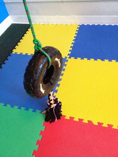 a toy tire is tied to a piece of foam on the floor in front of a door