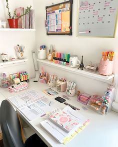 an office desk with lots of stationery items on it, including pens and pencils