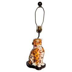 a lamp with a leopard sitting on it's side and the light is turned on