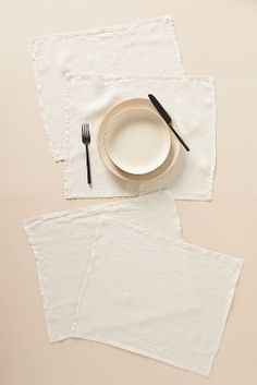 two napkins and a plate on top of each other with black utensils