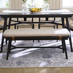 a dining table with four chairs and a bowl of lemons on top of it