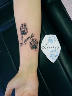 a person with a tattoo on their arm and paw prints in the shape of letters