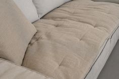 a close up view of a couch with two pillows on the back and one arm