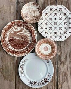 four plates sitting on top of a wooden table next to each other with different designs