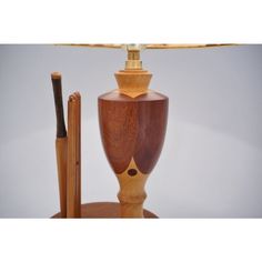 a wooden table lamp next to an umbrella holder with a stick sticking out of it