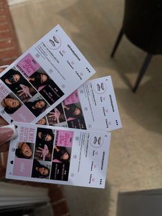 a person holding up four tickets for a concert with pictures on them and the ticket is being held in their hand