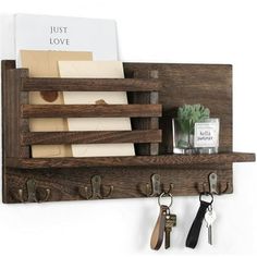 a wooden shelf with keys, notepads and other items hanging on the wall