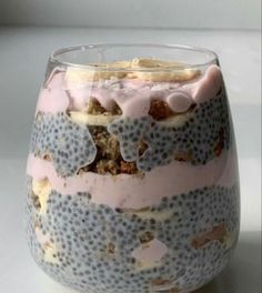 a close up of a dessert in a glass on a white table with blue dots