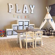 a play room with a teepee tent, table and chairs in front of it